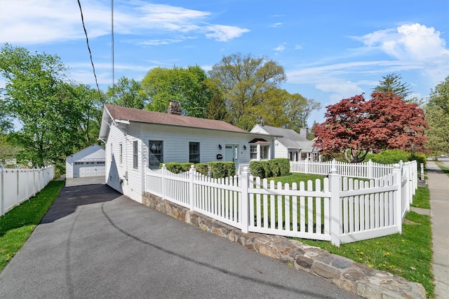 15 Elmore Ave, Croton-On-Hudson, NY 10520 - view of front facade with a chimney, an outdoor structure, a fenced front yard, a garage, and a shingled roof