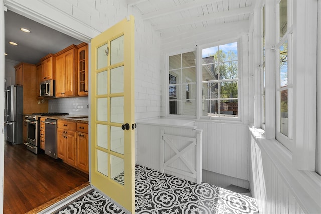 15 Elmore Ave, Croton-On-Hudson, NY 10520 - interior space with stainless steel appliances, tasteful backsplash, lofted ceiling with beams, brown cabinets, and glass insert cabinets