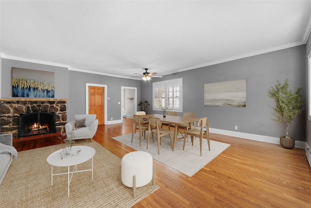 15 Elmore Ave, Croton-On-Hudson, NY 10520 - dining room with wood finished floors, crown molding, a ceiling fan, a fireplace, and baseboards