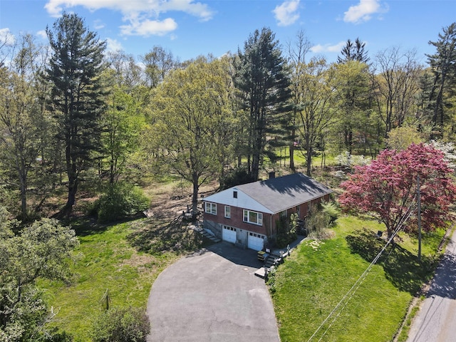 bird's eye view with a wooded view