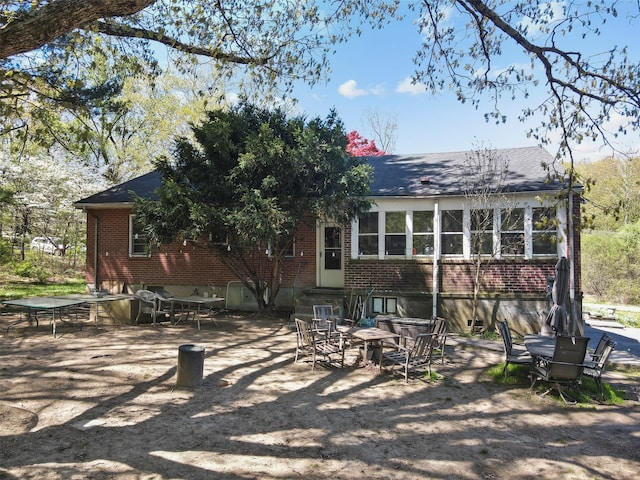 back of property featuring brick siding
