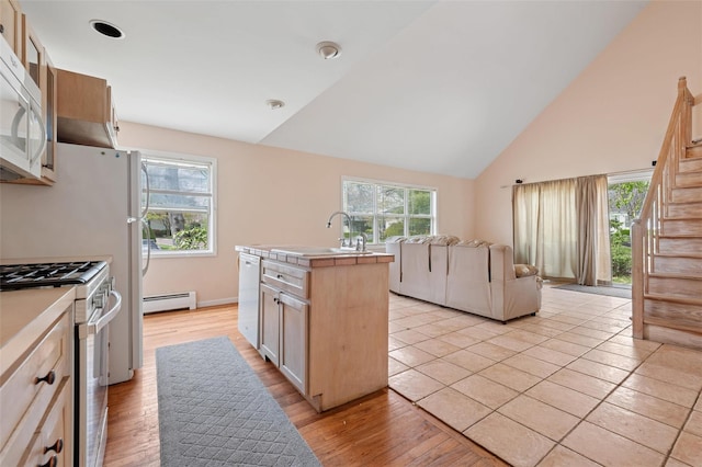 2 Heather Dr, Remsenburg, NY 11960 - kitchen with baseboard heating, white appliances, a sink, high vaulted ceiling, and a kitchen island with sink
