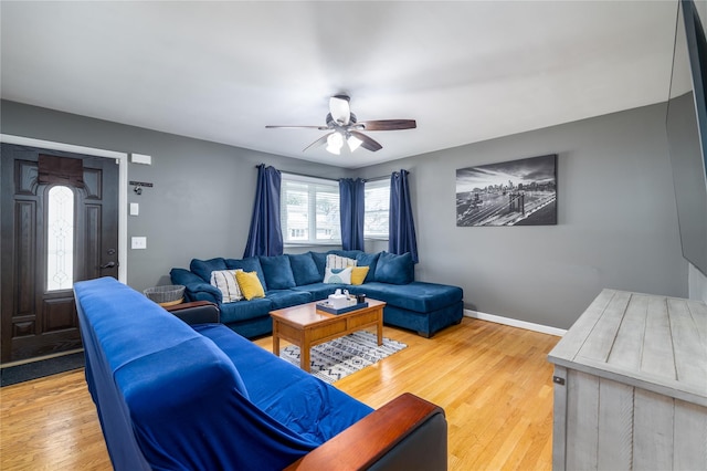 living room featuring light wood-type flooring, a ceiling fan, and baseboards