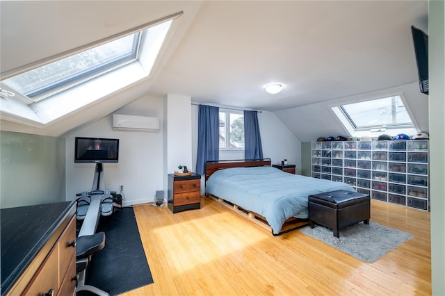 bedroom with lofted ceiling with skylight, a wall mounted air conditioner, and wood finished floors