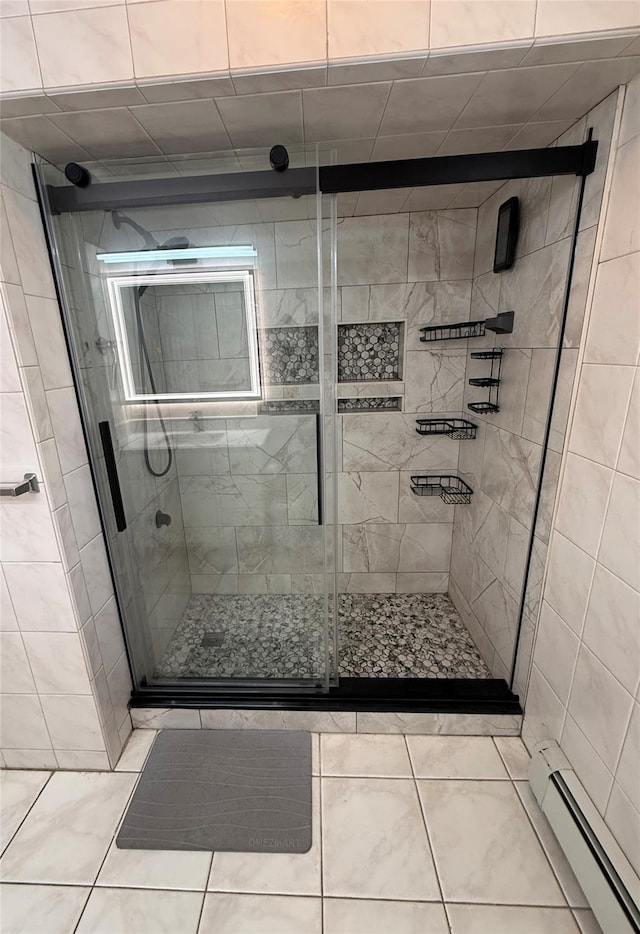 bathroom with tile patterned floors, a baseboard heating unit, and a stall shower