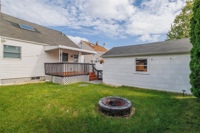 view of yard with a deck and an outdoor fire pit
