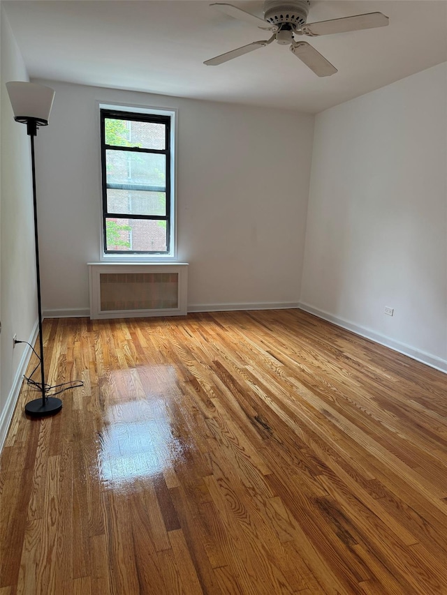empty room featuring baseboards, a ceiling fan, and wood finished floors