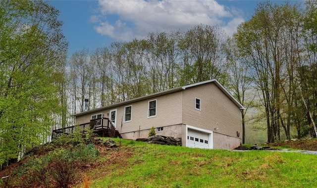 back of house featuring an attached garage, stairs, and a wooden deck
