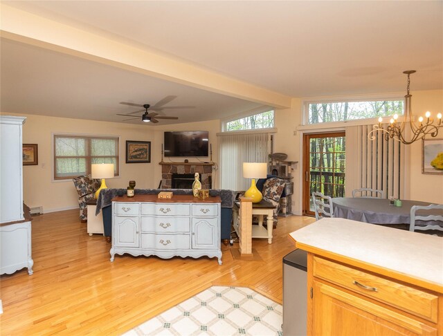 kitchen with open floor plan, light wood-style floors, ceiling fan, a baseboard heating unit, and a chandelier
