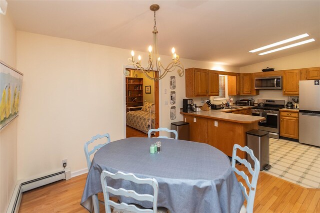 dining room featuring a chandelier, a baseboard heating unit, vaulted ceiling, and light wood finished floors