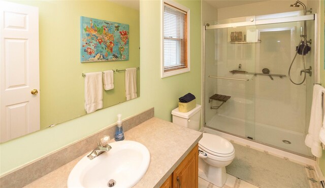 bathroom with a stall shower, vanity, and toilet