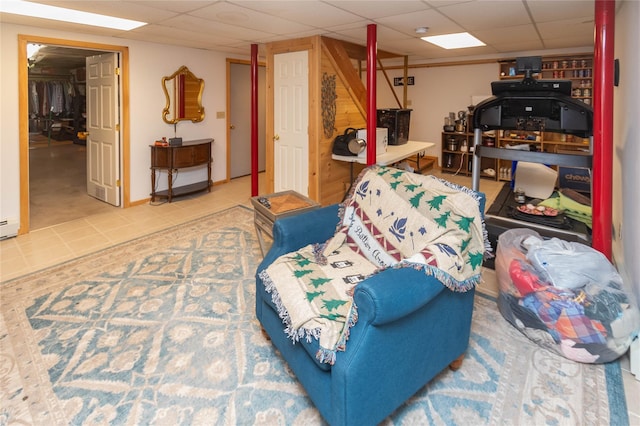 sitting room featuring a drop ceiling and tile patterned floors