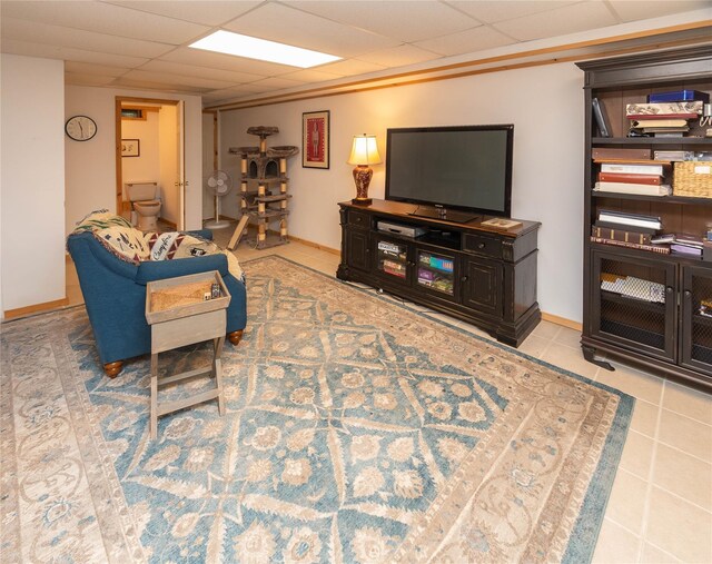 living room featuring a drop ceiling and tile patterned flooring