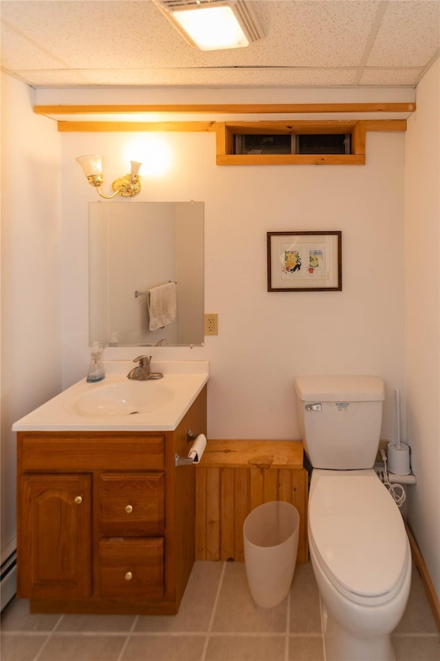 bathroom featuring vanity, toilet, tile patterned flooring, a paneled ceiling, and a baseboard radiator