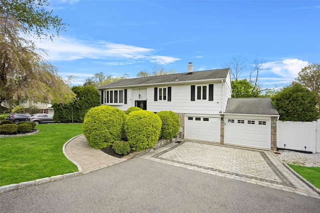 view of front of property featuring a chimney, fence, stone siding, aphalt driveway, and a front lawn