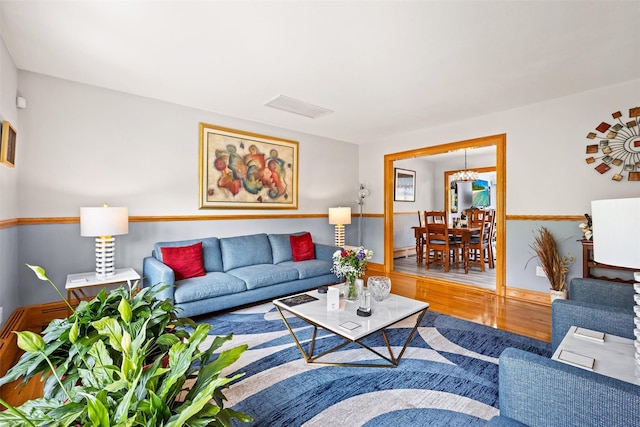 living area with baseboards, visible vents, and wood finished floors