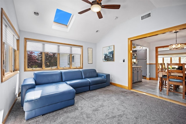carpeted living room featuring a ceiling fan, recessed lighting, baseboards, lofted ceiling with skylight, and visible vents