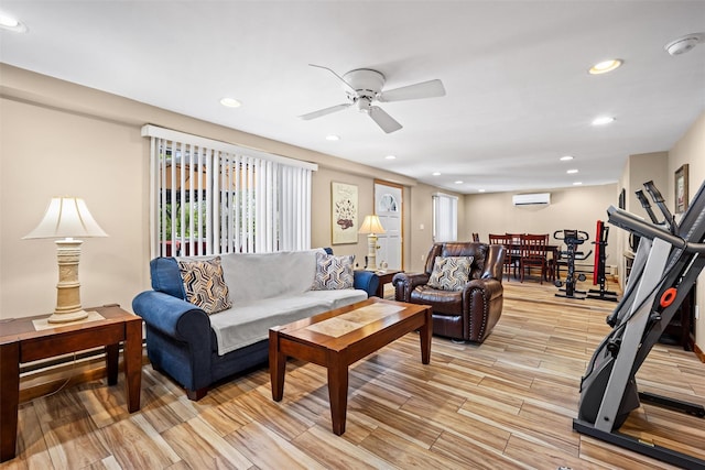 living room featuring ceiling fan, light wood-style flooring, a wall mounted air conditioner, and recessed lighting