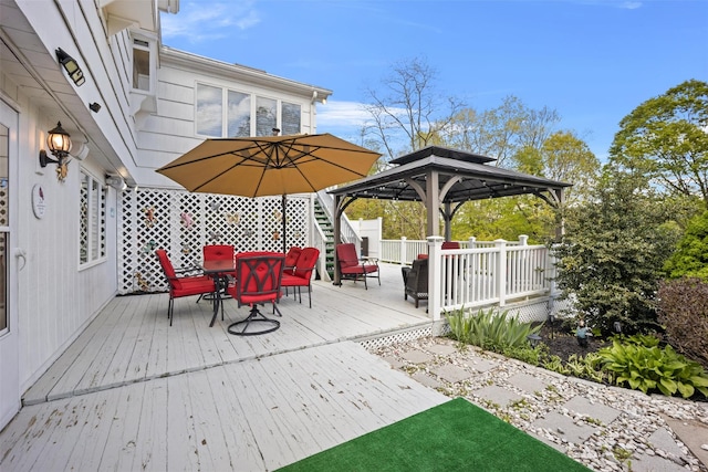wooden terrace with a gazebo and outdoor dining area