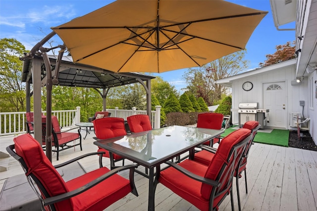 wooden deck with a gazebo, grilling area, and outdoor dining area