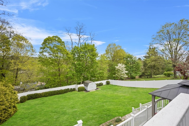 view of yard featuring an outdoor structure, a gazebo, a fenced backyard, and a shed