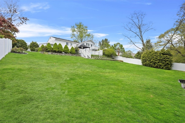 view of yard with stairs, a deck, and a fenced backyard