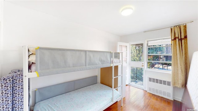 unfurnished bedroom featuring radiator and wood finished floors