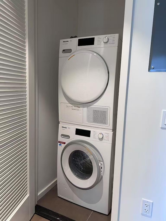 laundry room with stacked washing maching and dryer