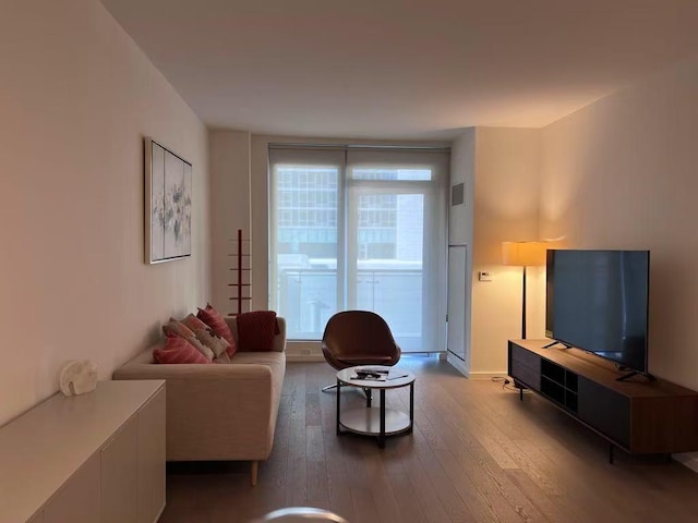 living area with wood-type flooring and baseboards
