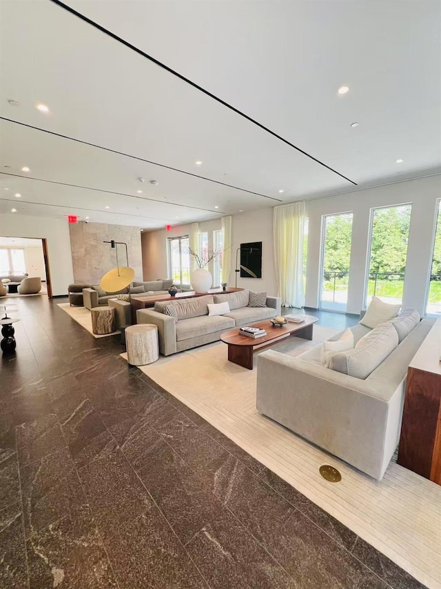 living area with recessed lighting and granite finish floor