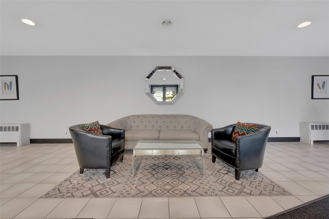 living room with radiator, baseboards, and light tile patterned floors