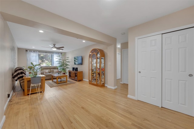 living room with light wood finished floors, baseboards, a ceiling fan, and recessed lighting