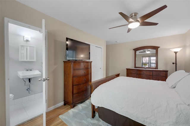 bedroom with a ceiling fan, baseboards, light wood finished floors, and a closet