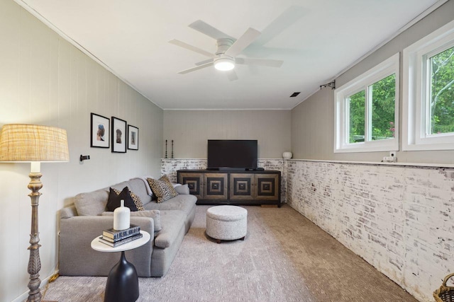 living area with carpet flooring, crown molding, and a ceiling fan
