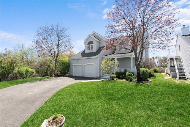 exterior space featuring a front lawn, an attached garage, aphalt driveway, a porch, and stairway