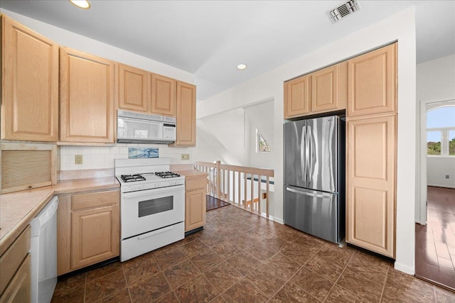 kitchen with light countertops, light brown cabinets, white appliances, and visible vents