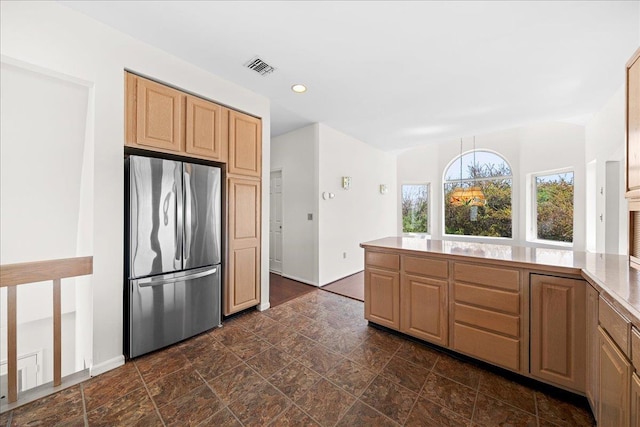 kitchen with stone finish floor, visible vents, freestanding refrigerator, a peninsula, and recessed lighting