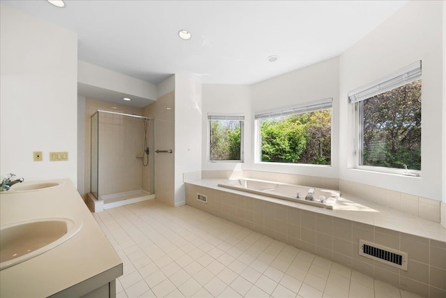 full bath with tile patterned flooring, visible vents, a sink, and a garden tub