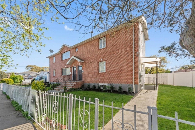view of front of house featuring brick siding, a fenced front yard, and a front yard