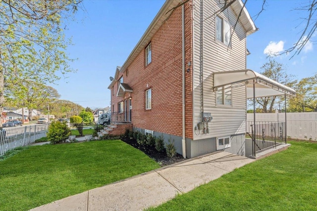 view of property exterior featuring a lawn, fence, and brick siding