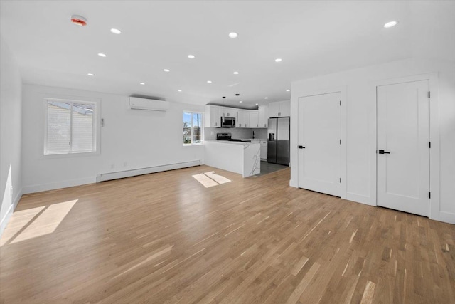 unfurnished living room featuring baseboards, baseboard heating, recessed lighting, a wall unit AC, and light wood finished floors
