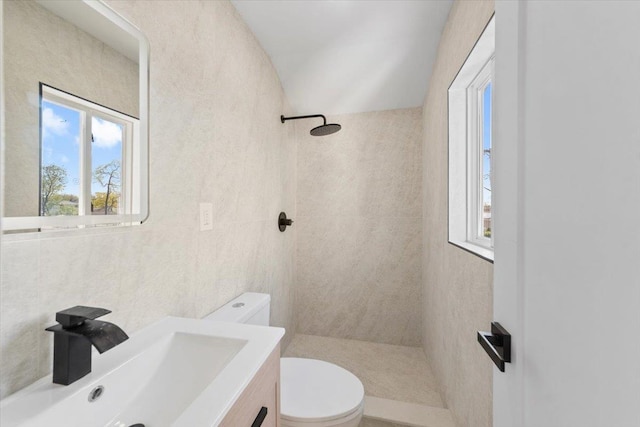 full bathroom featuring vanity, a tile shower, and toilet