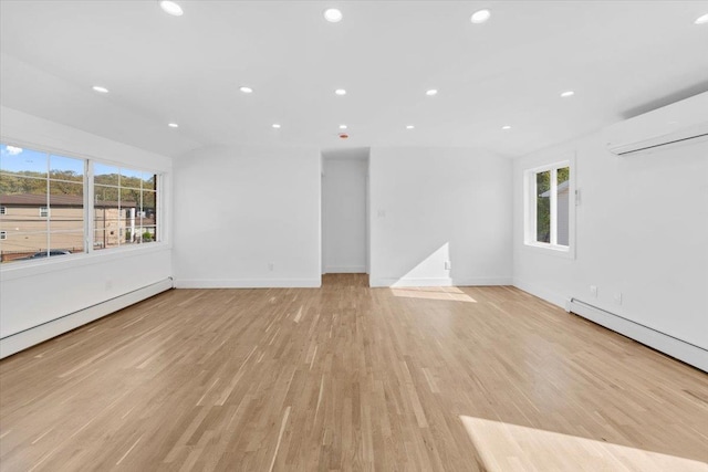 unfurnished living room featuring recessed lighting, a wall unit AC, and a healthy amount of sunlight