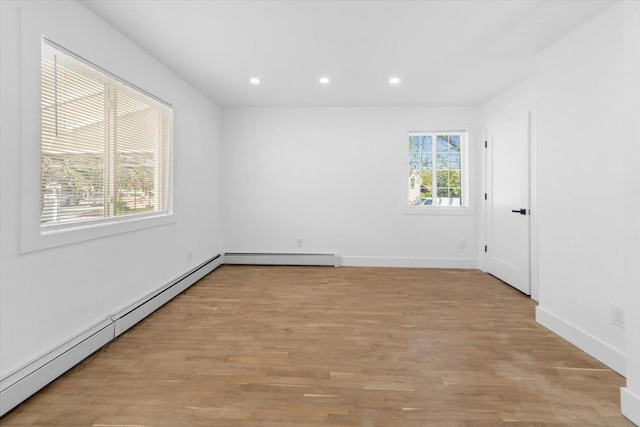 unfurnished room with baseboards, baseboard heating, recessed lighting, and light wood-style flooring