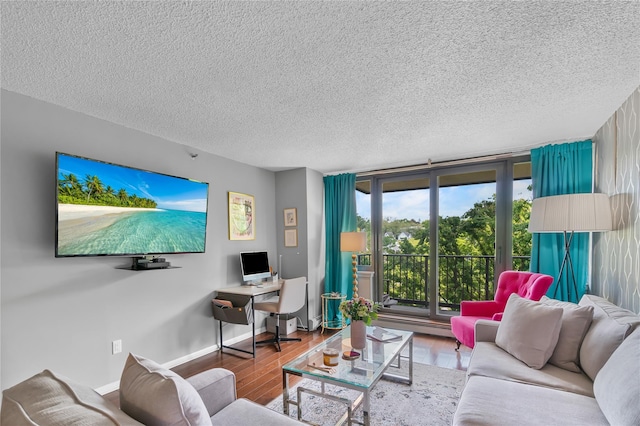 living area featuring a textured ceiling, wood finished floors, baseboards, and a baseboard heating unit