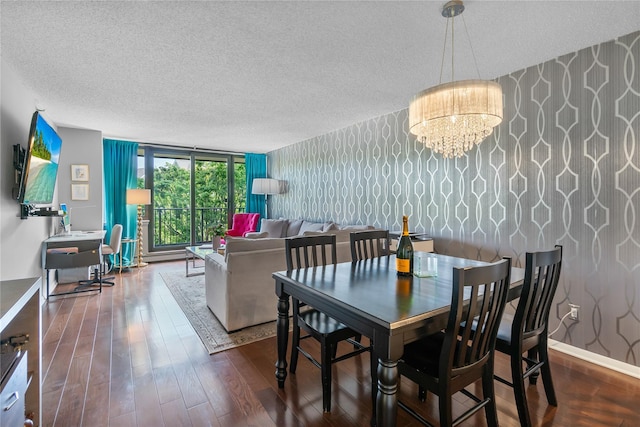 dining space with wallpapered walls, a textured ceiling, wood finished floors, and a notable chandelier