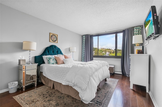bedroom featuring baseboards, a baseboard radiator, a textured ceiling, and wood finished floors