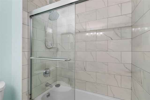 bathroom featuring toilet and enclosed tub / shower combo