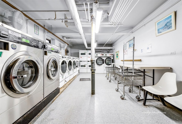 community laundry room featuring stacked washer / dryer, tile patterned floors, and washer and clothes dryer