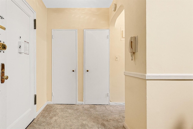 hallway featuring carpet floors and baseboards